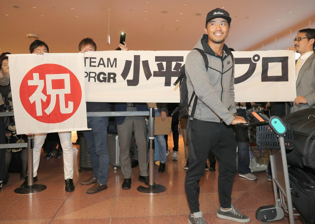 羽田空港に帰国し、横断幕の前で笑顔を見せる小平智