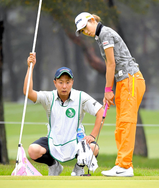 ８番グリーンで塚田陽亮（左）とパットのラインを確認する金田久美子