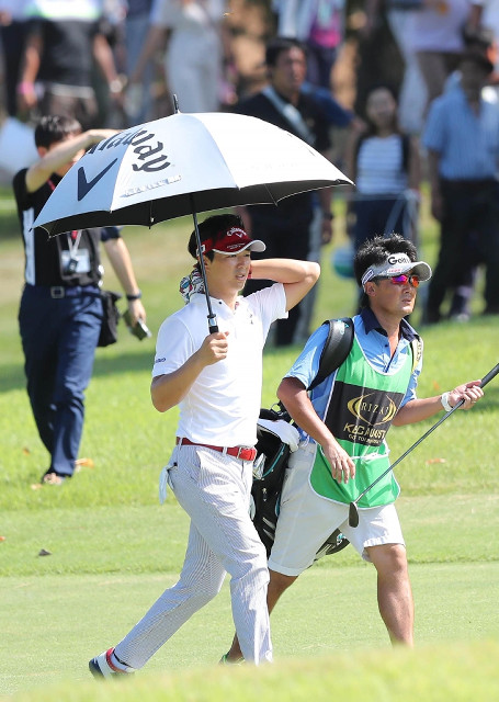 移動中、首に氷のうを当てながら歩く石川遼（カメラ・渡辺　了文）