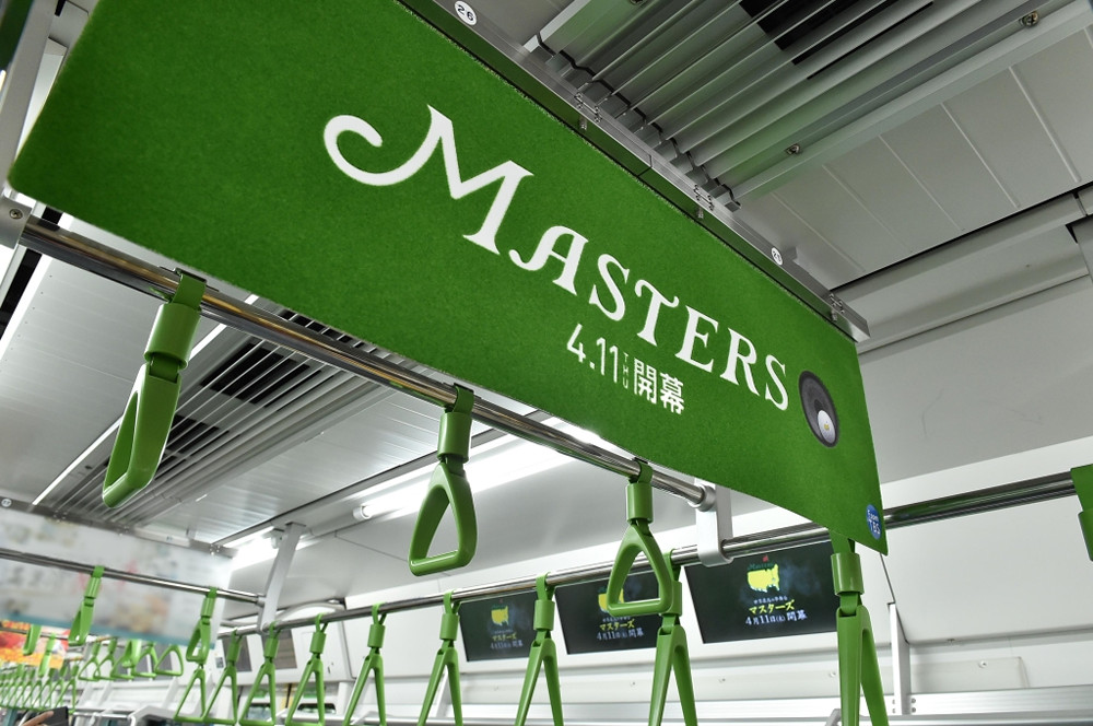 山手線内に登場したマスターズを宣伝する鮮やかな緑色の芝生ポスター