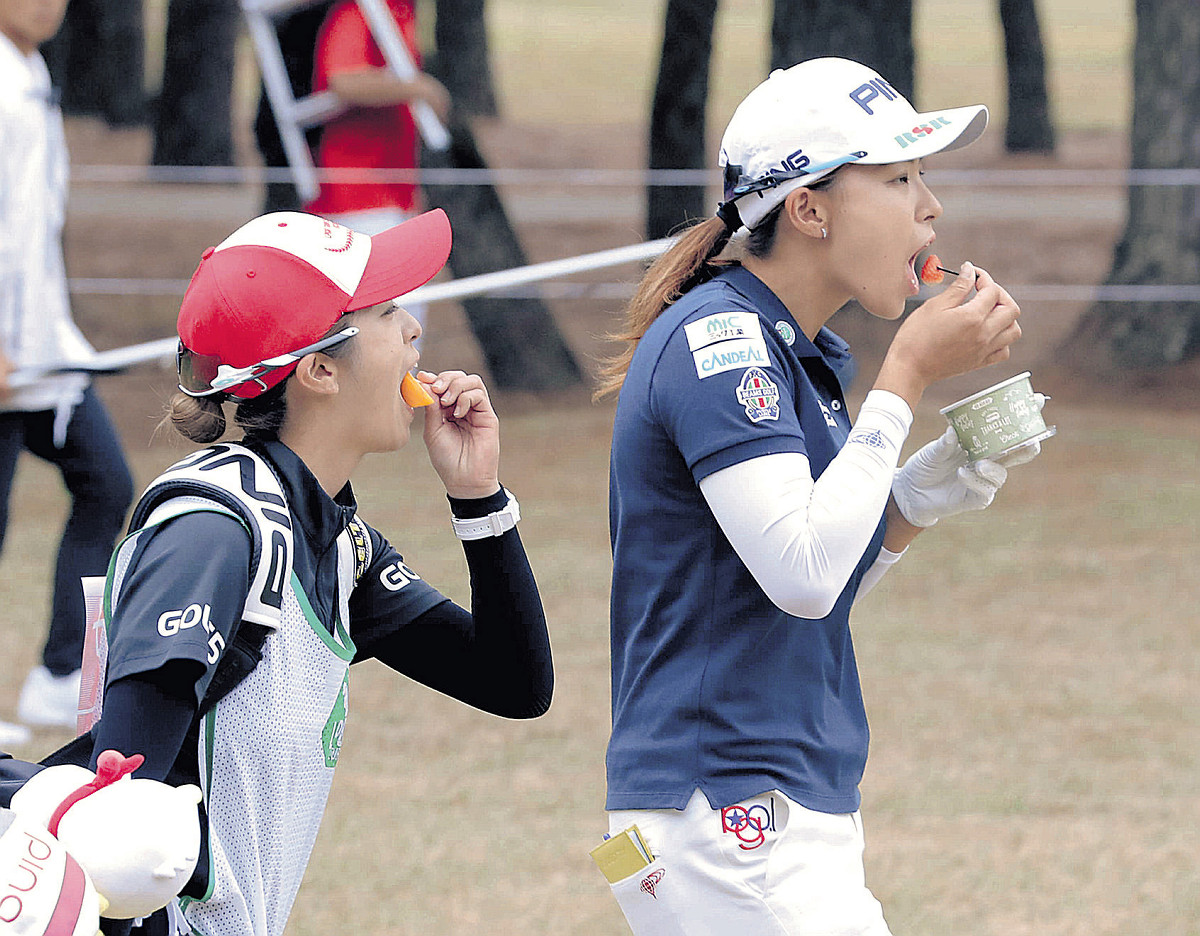 １８番、キャディーと果物を食べながら歩く渋野