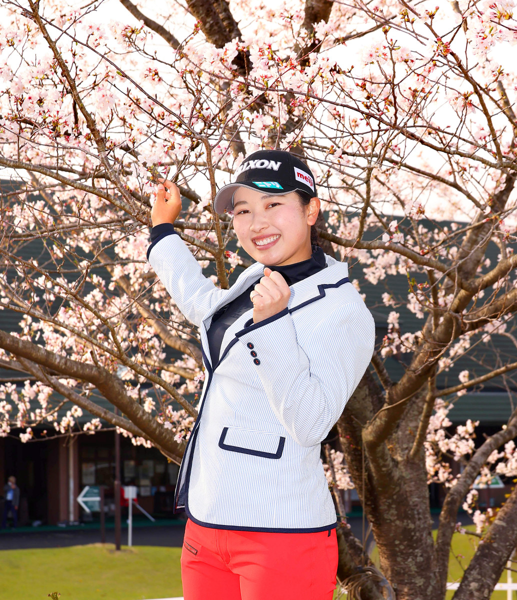 通算１０アンダーで逆転優勝を果たした小祝さくらは、桜の枝に手を添えて笑顔でポーズをとった（カメラ・豊田　秀一）