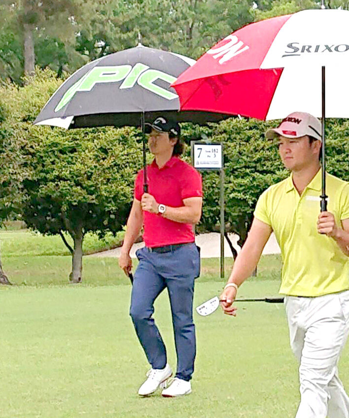 雨の中、スコアを落とした石川遼（右は香妻陣一朗）