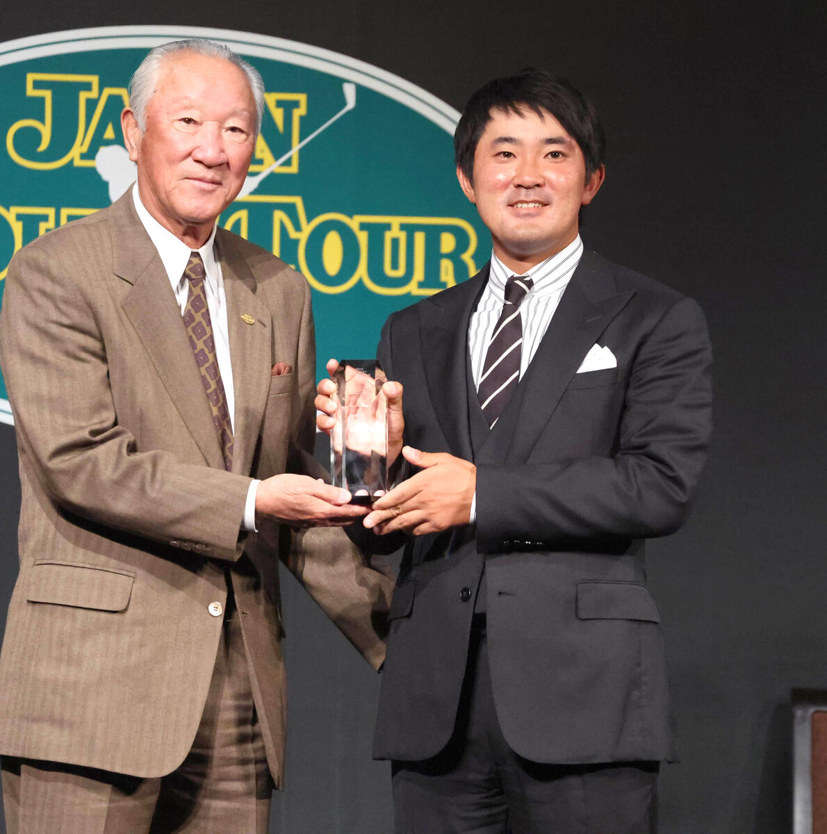 トータルドライビング賞の金谷拓実（左はJGTO・青木功会長）　（カメラ・堺　恒志）