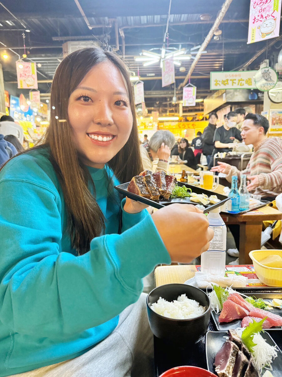 ひろめ市場で名物カツオを堪能する仁井（提供写真）