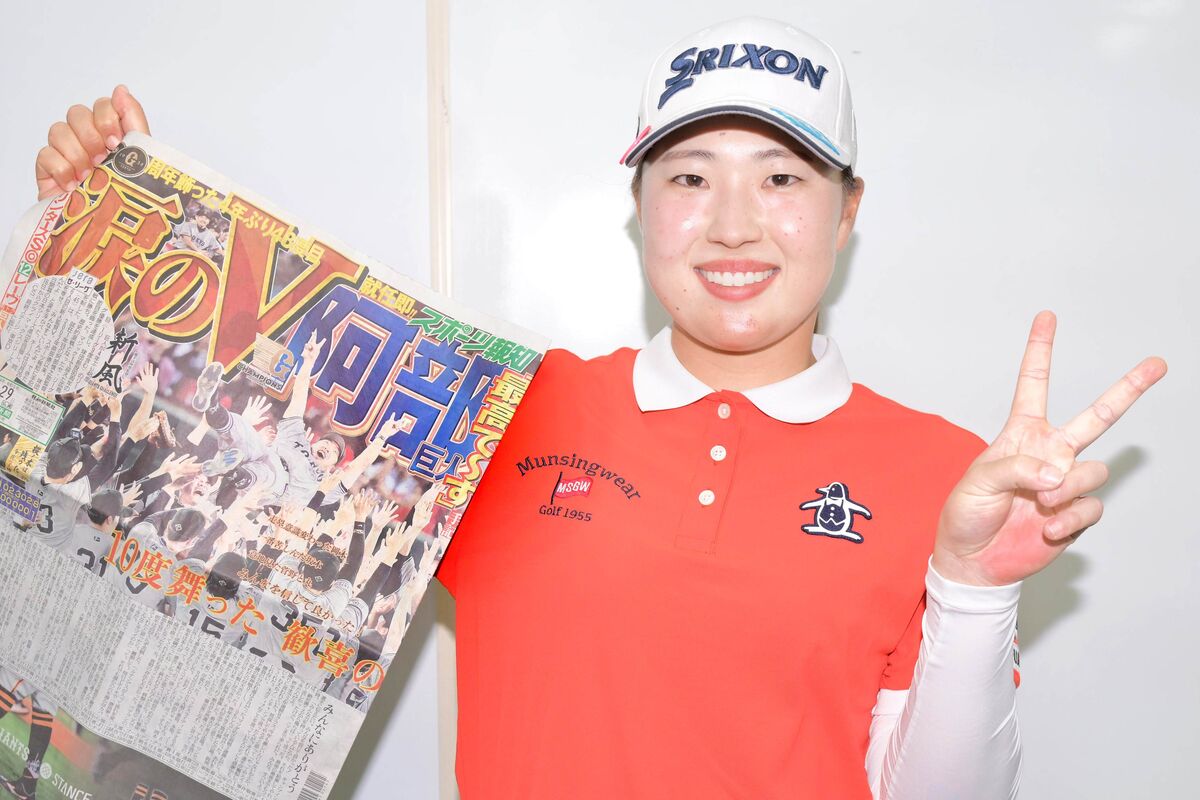 熱烈な巨人ファンの竹田麗央は、優勝を報じたスポーツ報知の紙面を手にVサイン（カメラ・今西　淳）