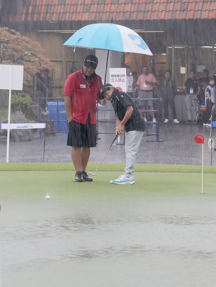 大雨の中、練習グリーンでパッティングの練習をする福井誠ノ介（カメラ・馬場　秀則）