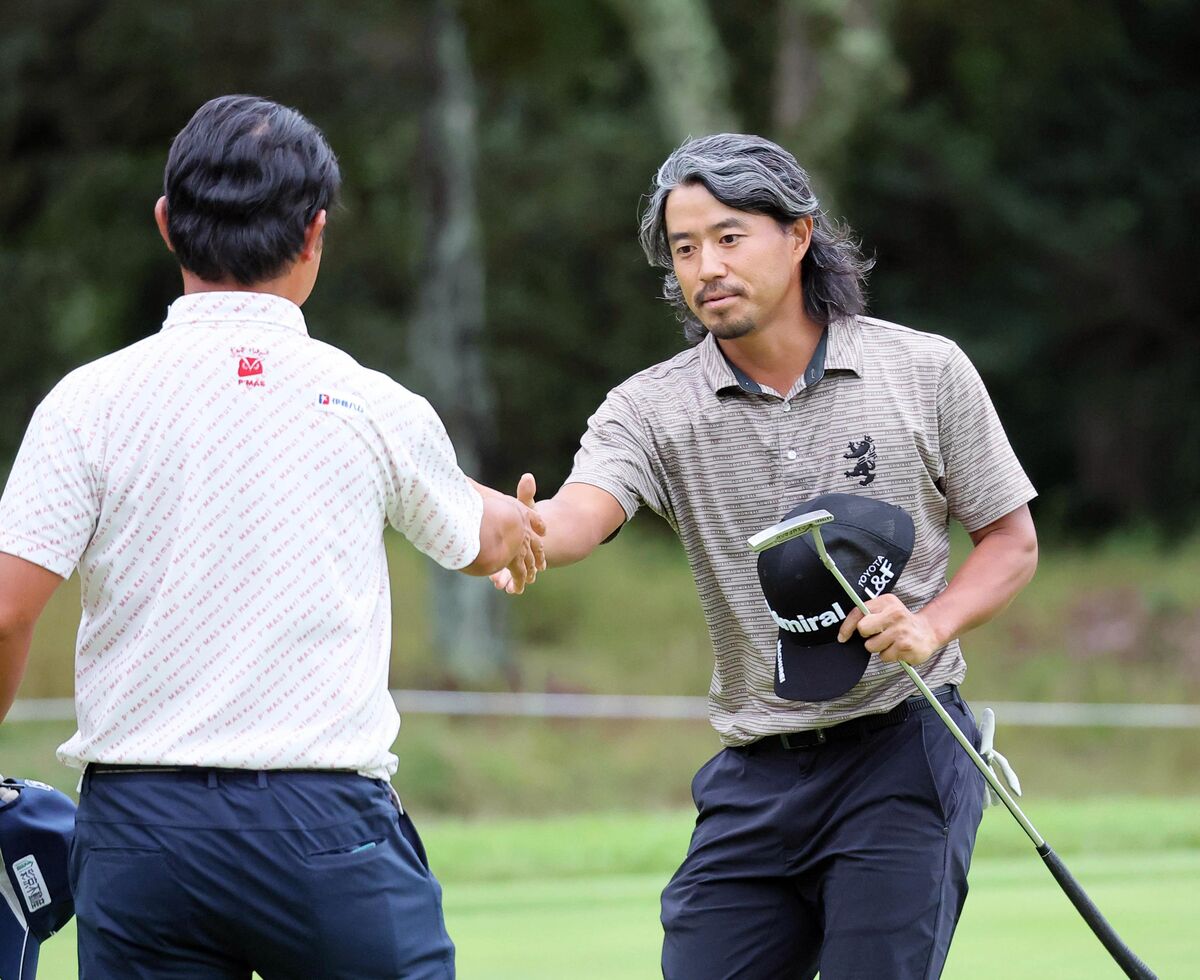 ホールアウトし、同組の市原弘大（左）と握手をする小平智　（カメラ・馬場　秀則）